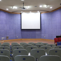 뒤에서 바라본 시청각실 사진 의자와 강단위에 화이트보드, 빔프로젝트가 위치해있다