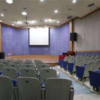 뒤에서 바라본 시청각실 사진 의자와 강단위에 화이트보드, 빔프로젝트가 위치해있다